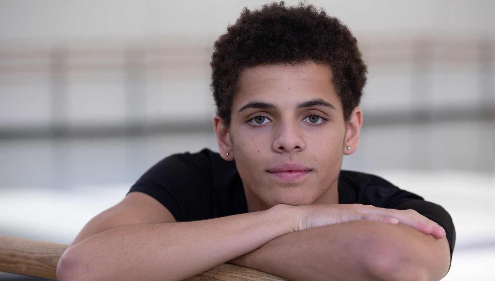 teen-boy-dancer-leans-on-ballet-bar