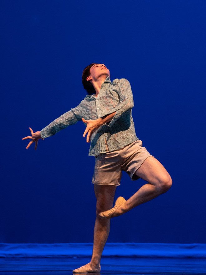 Male dancers stands on one leg with head thrown back