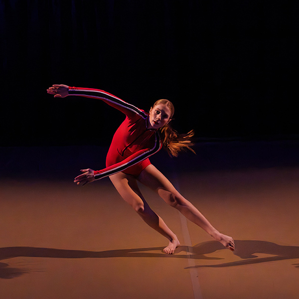 A contemporary dancer performing in red leotard