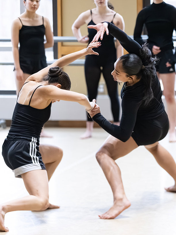 Dancers hold hands as they danc across floor